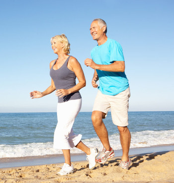 Image of a senior couple exercising along the beach.