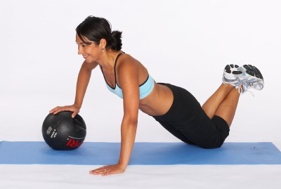 Image of a female client using a medicine ball in her fitness workout.