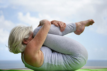 A female older adult performing a flexibility drill.
