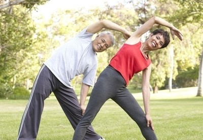 Image of an older couple exercising in a park.