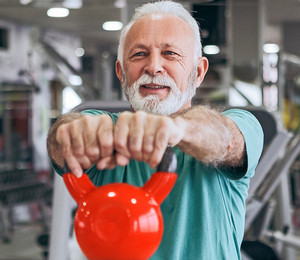 Image of a senior man exercising with a kettlebell.