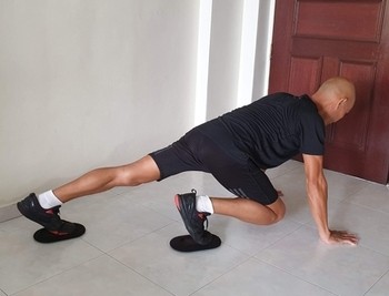 Image of an exercise performed with sliders on both feet.