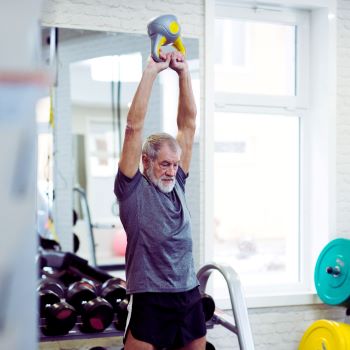 Image of a senior male performing power training in the gym.