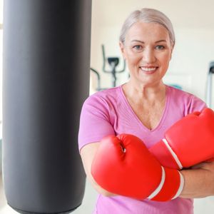 Image of senior lady engaging in a cardio kickboxing workout.