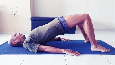 Image of a mid-life male performing a glute bridge.