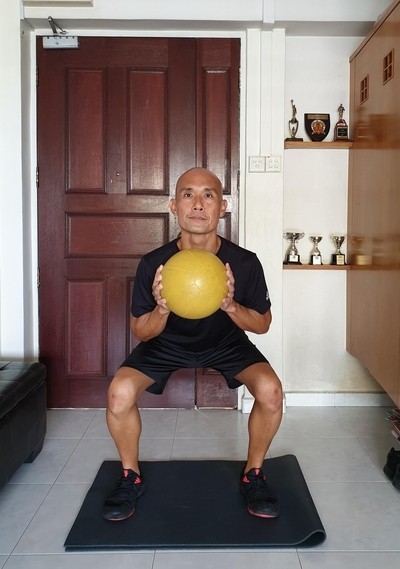 Image of a mid-life adult performing a functional squat.