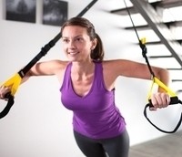 Image of woman exercising with a suspension trainer.
